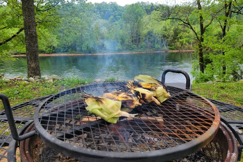 Cooking over an open fire pit by the lake